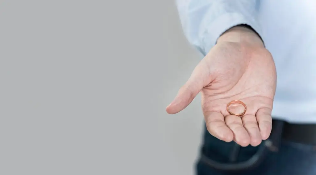 close-up-hand-holding-wedding-ring