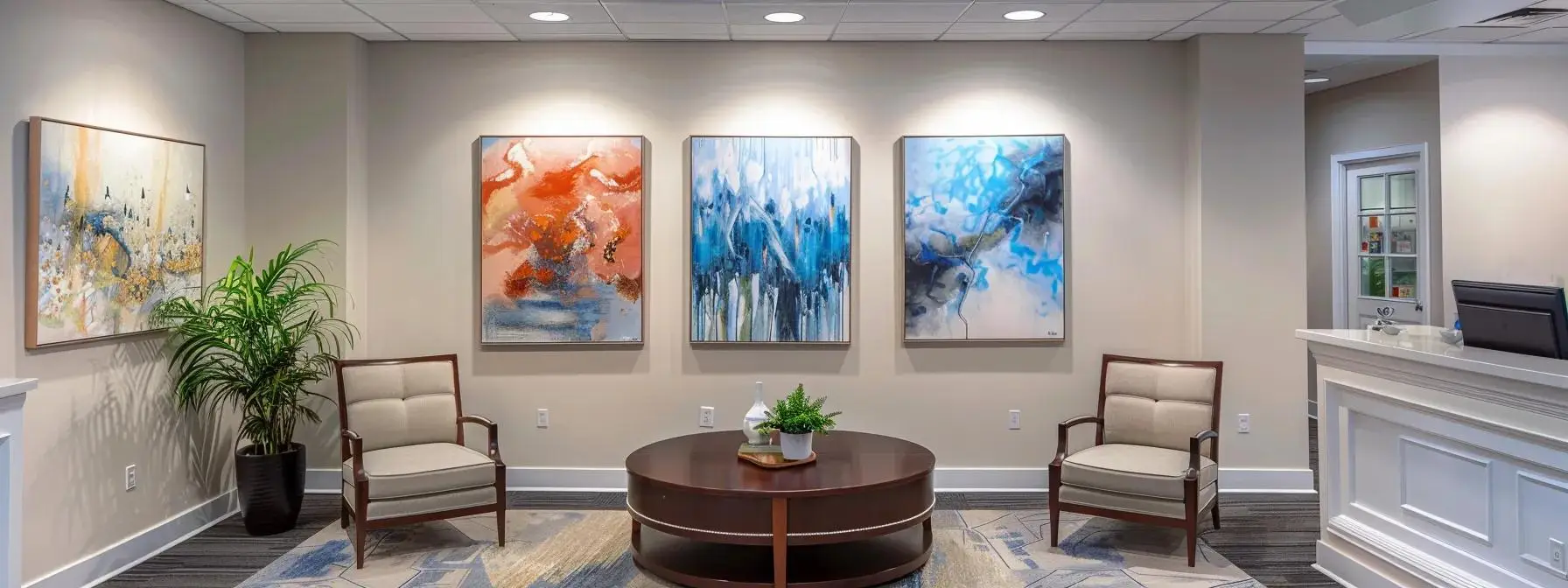 a professional and inviting office space features a round table set for mediation, with two comfortable chairs opposite each other, surrounded by light-colored walls adorned with abstract art, capturing the essence of texas divorce mediation in a serene yet purposeful environment.